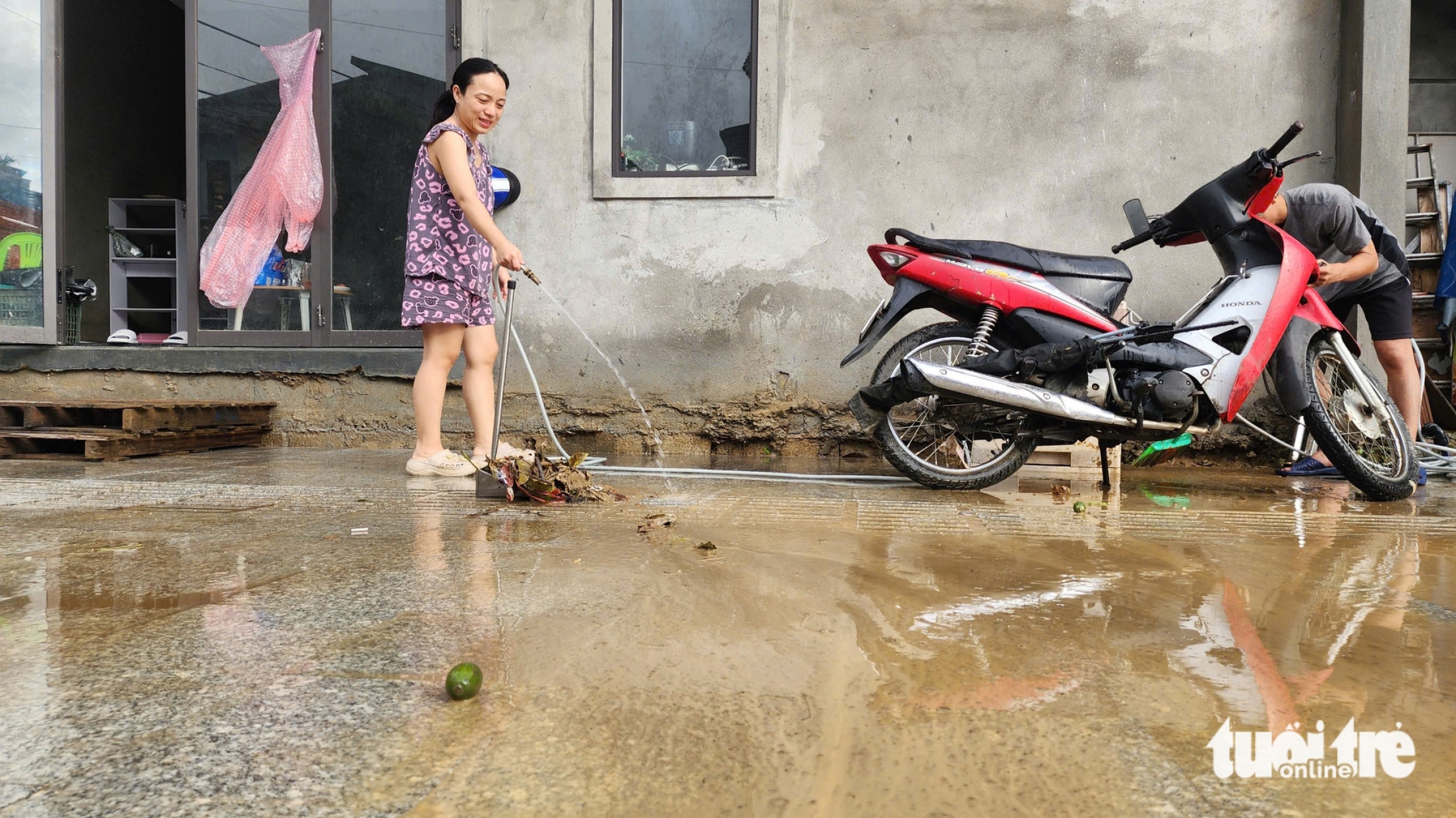 顺化在连续多日大雨后迎来阳光,居民趁洪水退去清理淤泥